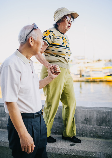 An old couple taking a walk together for exercise near the water