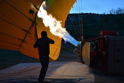 Picture of a man filling his hot air balloon preparing for flight