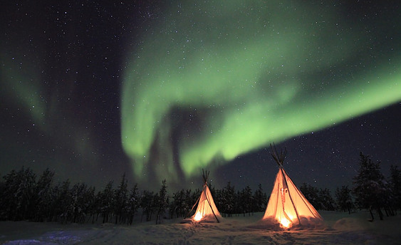 Picture of two Teepee`s at night under the aurora borealis