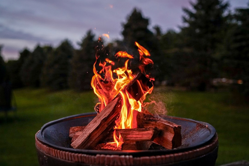 Picture of a firepit ablaze at dusk in an open field