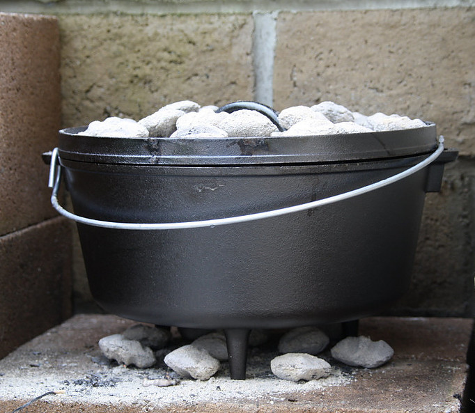 Picture of a Dutch oven with coals on top and underneath being displayed