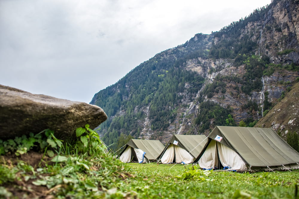 Three tents surrounded by mountains