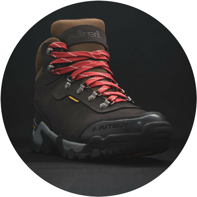 A quality brown hiking boot with red and white laces set in a black background