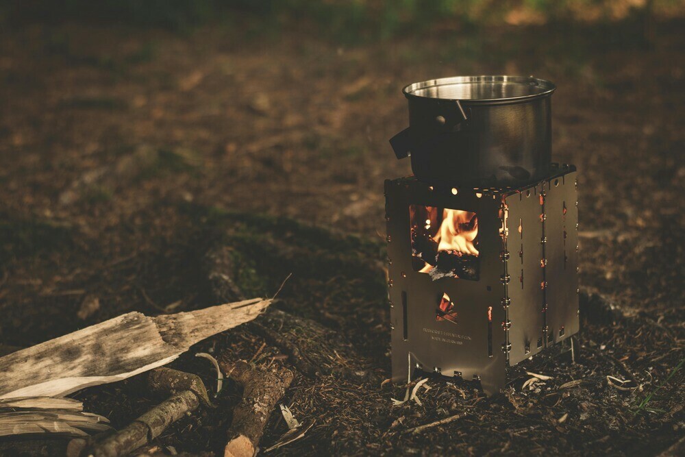 Cooking pot place on a wooden burning camping stove