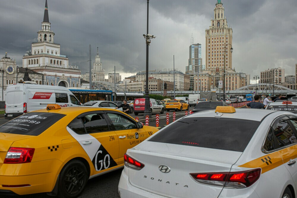 City scene showing a yellow and white taxi for hire