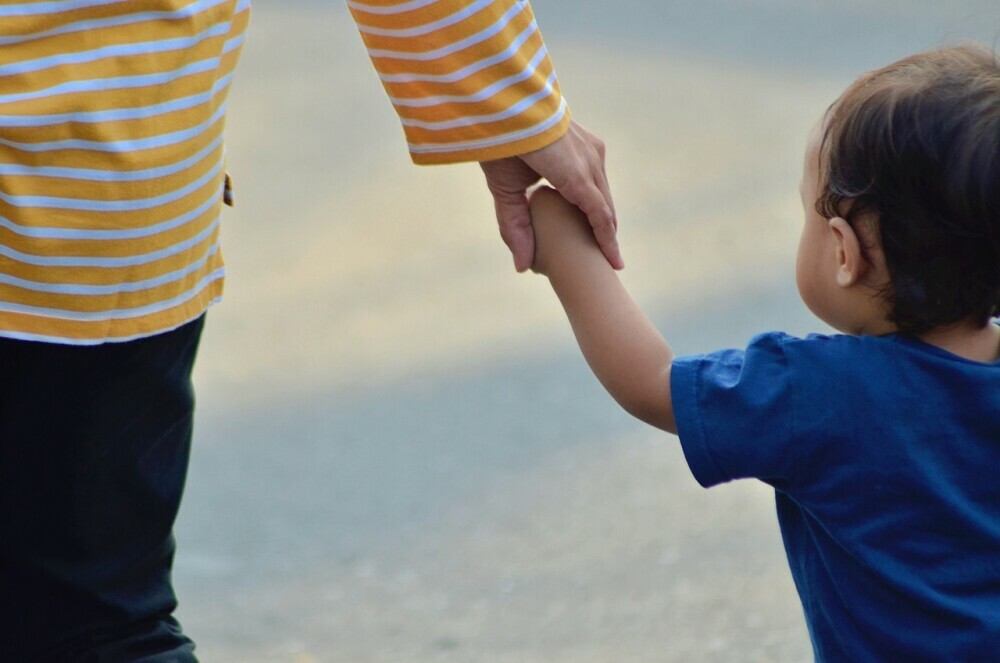 Parent holding their child`s hand