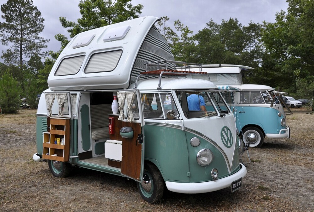 Volkswagen camper parked up with the side door open and the roof raised