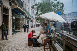 Individual having their boots polished by street shoe shiner